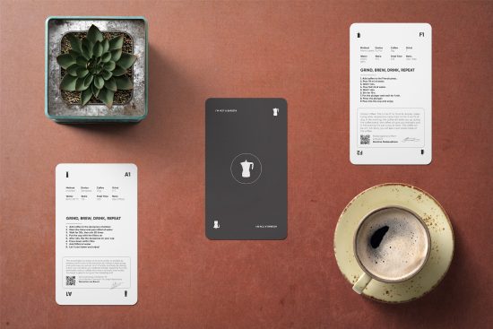 There are three brewing recipe cards on a table. To the bottom right is an empty coffee mug. To the top left is a small jar of whole coffee beans.