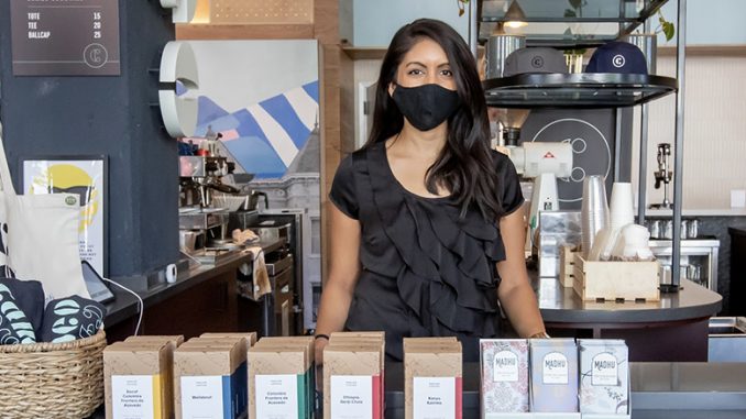 Cameo coffee director Nazia Khan stands behind coffees at the cafe.