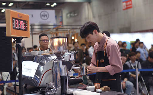 Hyun-young Bang prepares to steam a pitcher of milk at a barista competition.