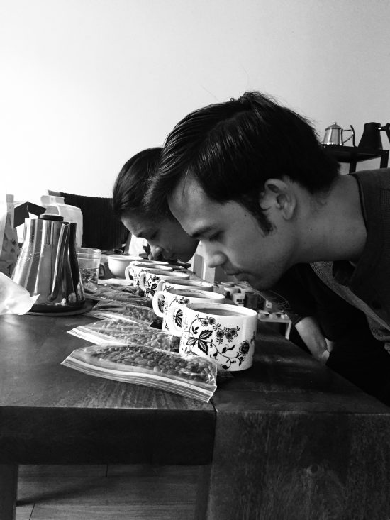 Baristas Matt Lapid and Selina Viguera put their faces close to coffee samples to sniff their aromas. We see side profiles of the two of them.