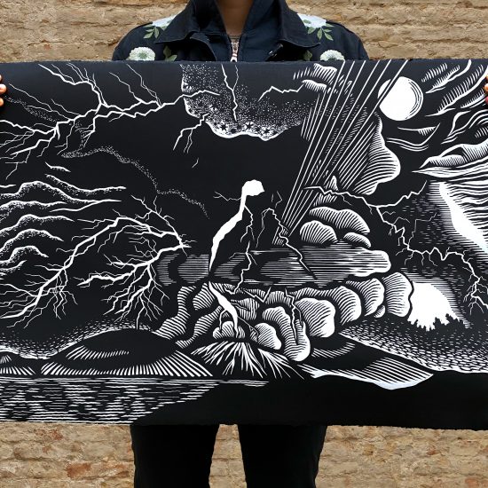 The artist from the shoulders down, holding another print of hers. It is an abstract design of a volcano erupting.