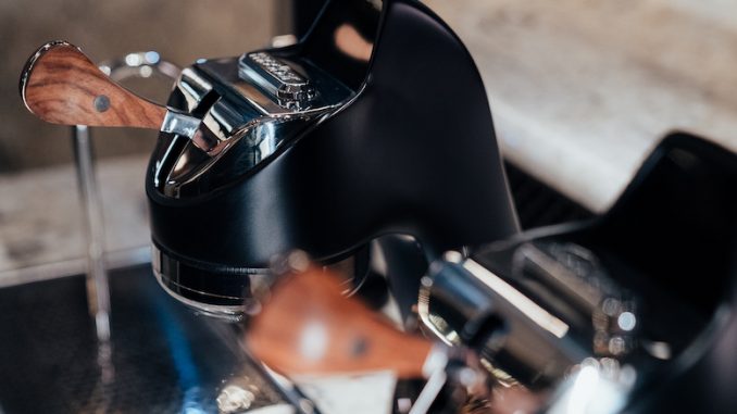 A closeup of a black Modbar countertop espresso machine.