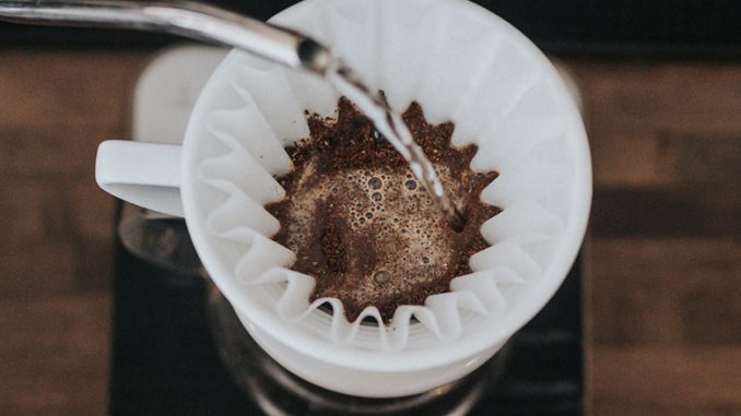 A closeup of water streams pouring into a bed of a coffee cone.