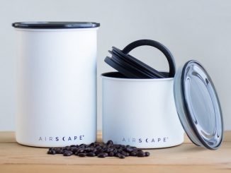 A product shot of white airscape cannisters. A handful of beans sits at the front.