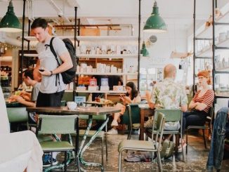 A generic cafe scene of bright lighting and folks indoors drinking coffee.