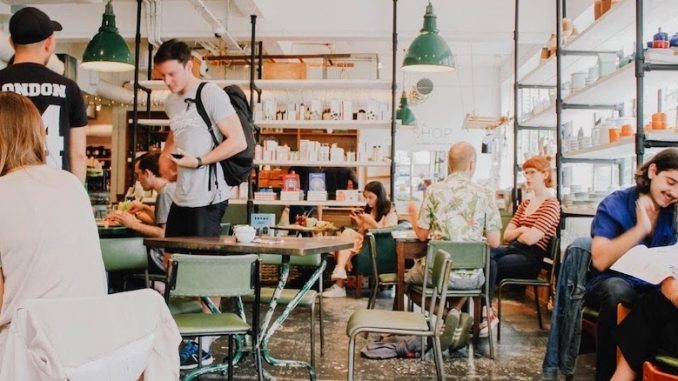 A generic cafe scene of bright lighting and folks indoors drinking coffee.