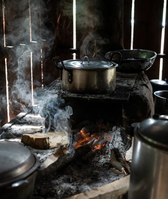 Three pots sitting on a woodfire stove.