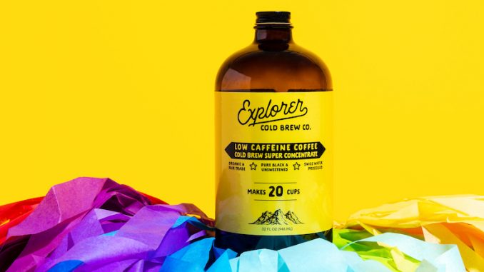 A bottle of cold brew amidst a yellow backdrop on top of a rainbow flag.