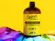 A bottle of cold brew amidst a yellow backdrop on top of a rainbow flag.