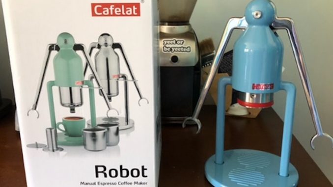 A closeup of the box of the cafelat robot next to the robot, a light blue machine.