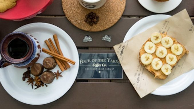 A closeup of plates holding toasts, coffee, and the back of the yards business card in the middle.