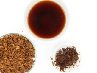 A set of three petri dishes holding cascara as a tea, a dry spice, and a fresh leaf.