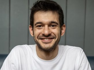 Alessandro Zengiaro is an Italian white man smiling wearing a white t shirt.