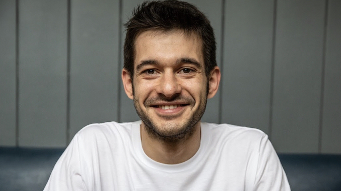 Alessandro Zengiaro is an Italian white man smiling wearing a white t shirt.