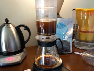The plastic tricolate brewer in the middle of brewing coffee.