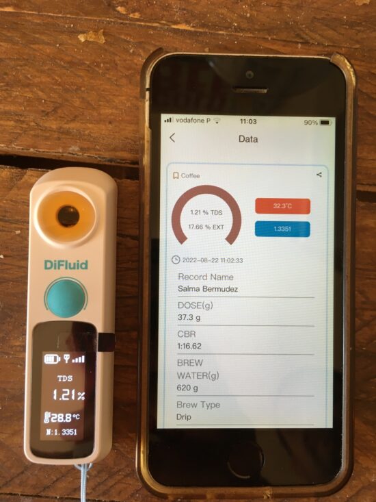 The DiFluid refractometer syncing data with an app on a smartphone.