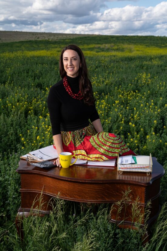 Jasmin McGinnis posing at a table in a field.