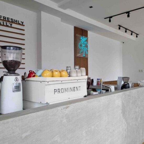 El bar de Prominent Coffee con máquina de espresso y molinillos.