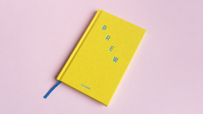 Fotoattēls grāmatas BREW priekšpusē, mazs dzeltens cietais vāks ar pievienotu zilas lentes grāmatzīmi.