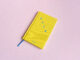 Photo of front of the book BREW, a small yellow hardback with attached blue ribbon bookmark.