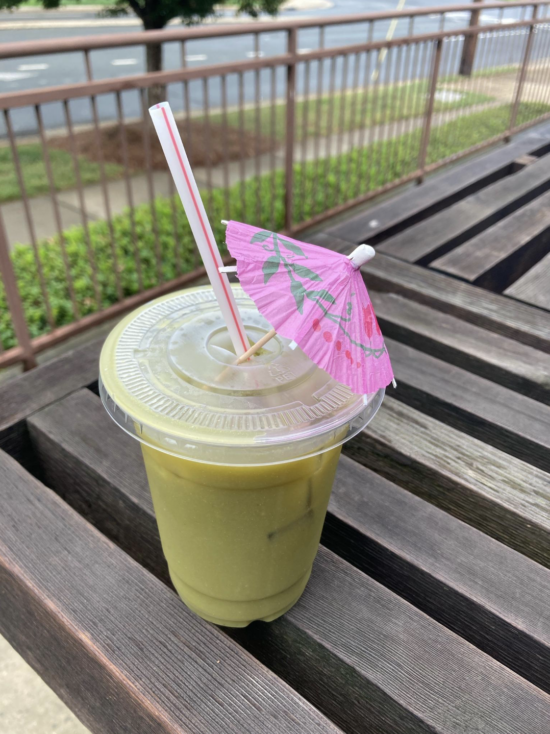 A Summer Samurai seasonal drink in a to-go cup on a wooden bench at Stable Hand in Charlotte, N.C.