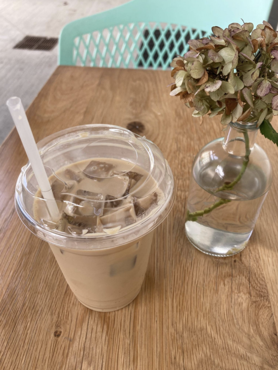 An Iced Maple Sea Salt Latte in a to go cup on a table.
