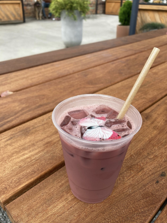 Сезонний напій Summertime Chai Tea Latte у чашці з собою на лавці в Summit Coffee у Шарлотті, Північна Кароліна