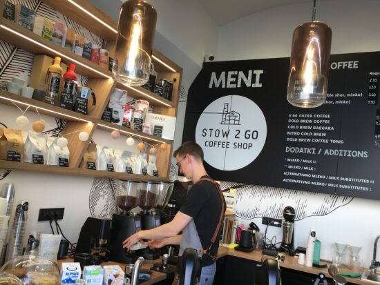 Inside Cafe Stow, a barista prepares an espresso drink behind the bar.hind th