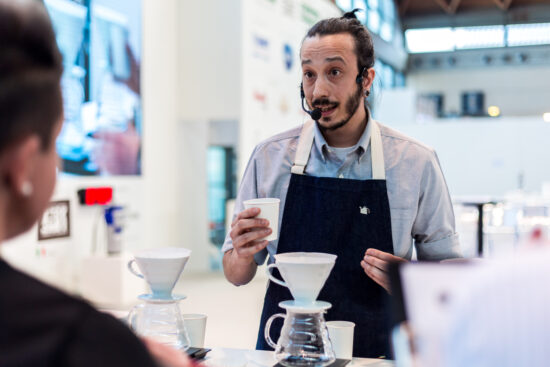 Gian Zaniol præsenterer en V60 skænk over kaffe ved en kaffekonkurrence