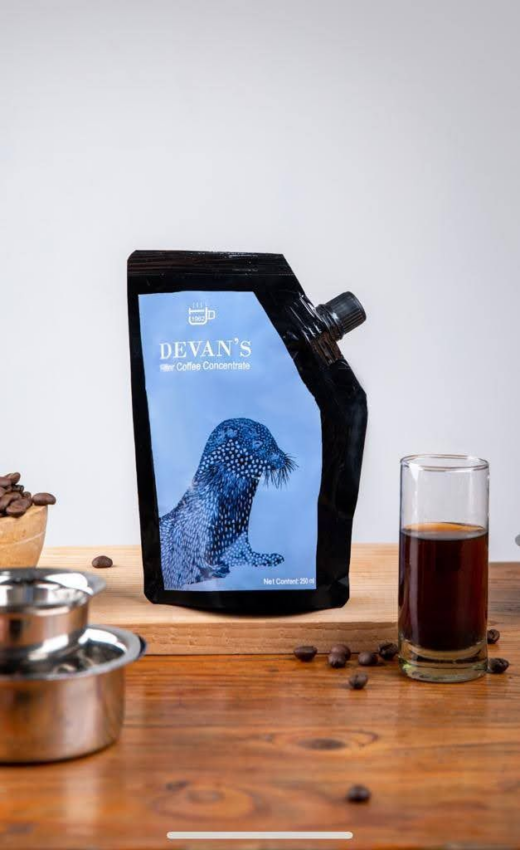 Devan's filter coffee concentrate comes in a black pouch with a plastic spout and screw cap on the side. A blue seal on a light blue background decorates the package.