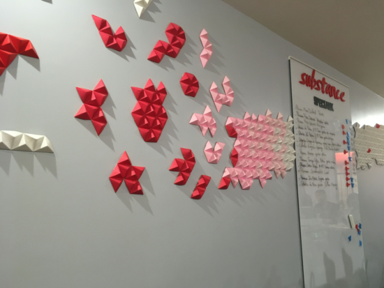 The back wall at Substance. Origami shapes pop in #D out from the white wall, in white, pink and red. 