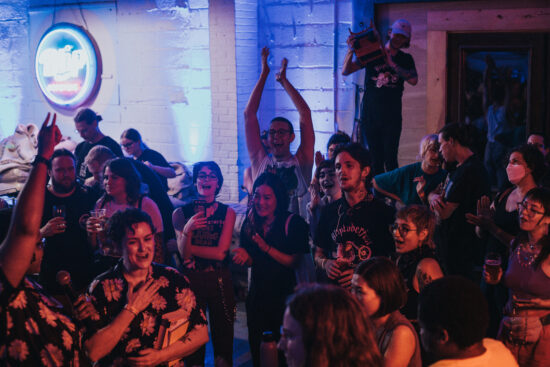 A rowdy crowd of people cheering for baristas in kansas City.