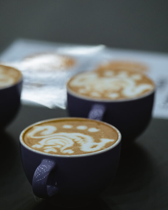 Latter art in two dark blue mugs, which appears to be a fancy seahorse design.