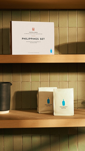 The Set box is white with room for two white Blue Bottle branded bags, which simply has an illustration of a blue corked bottle. At the top of the set's box is a red label for the Horizon Series of limited run coffees.