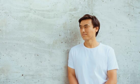 Retrato de perfil de Eric Park junto a Whote Wall. lleva una camiseta y mira hacia un lado.