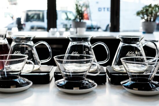 The Kalita Wave, seen here, has no ripples on the side, but is rounded, conical clear glass. It sits on a plastic base that will fit onto vessels.