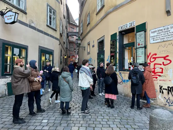 A line of people waits outside Fenster on the cobblestone street.
