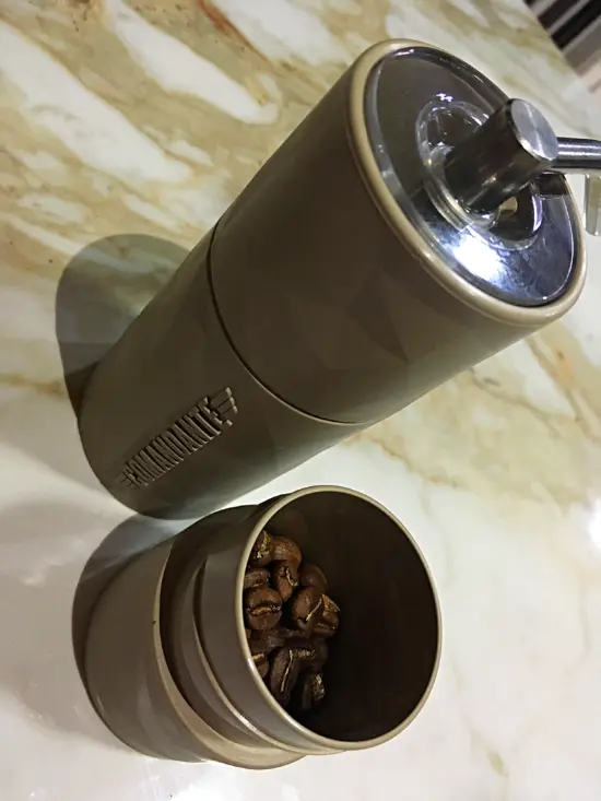 The grinder opened up to reveal the plastic cap, which you can use to measure the coffee beans.