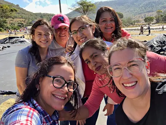 Seven women pose together outside