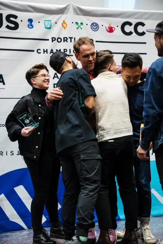 Isaiah receives hugs of congratulations from four friends after taking first place.