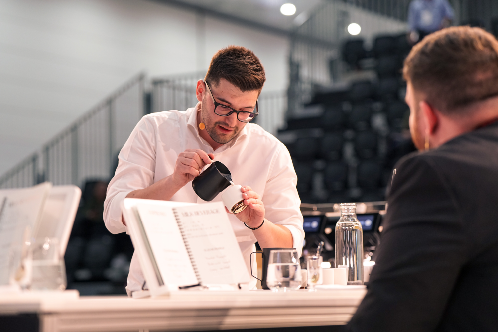 Nikos Antzaras pours milk for a latte during a barista competition.