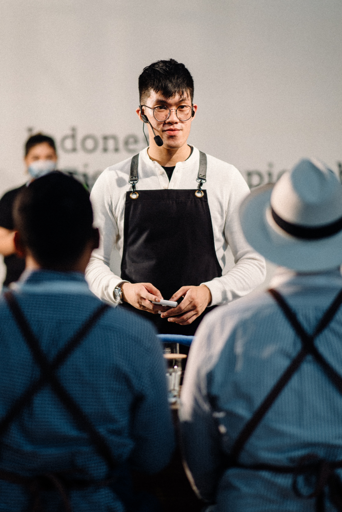 Patrik Vinsensius speaks to the judges at a barista competition.