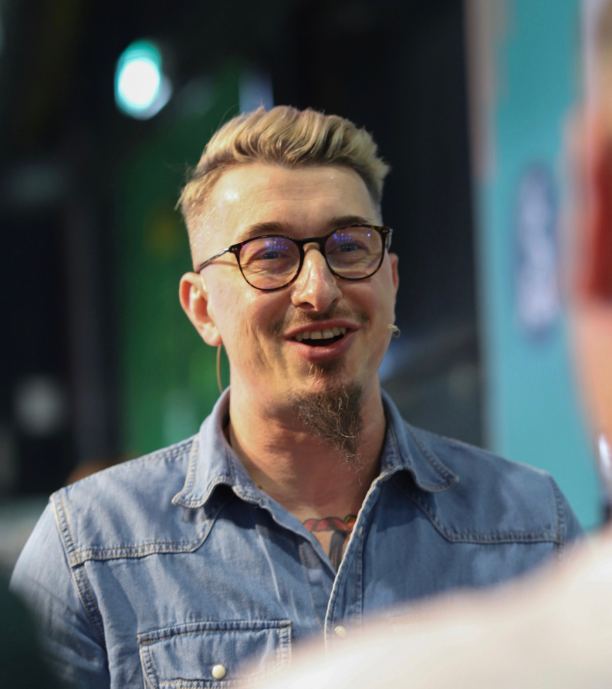 Wojciech Tysler smiles as he speaks to the judges during a barista competition.