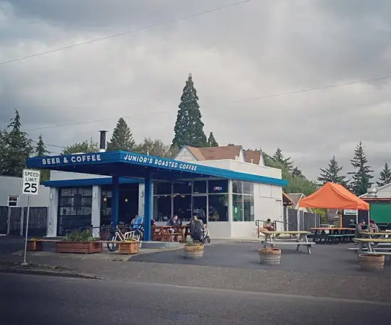 An old gas station converted into a coffee shop. The patio outside is covered by a blue 