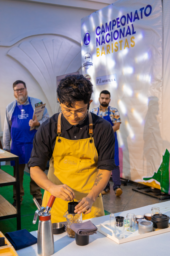 Benjamin Roque works on creating a signature drink as the judges watch at a barista competition.