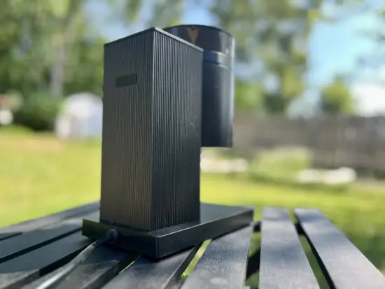 The back view of the streamlined Opus grinder, which sits on a small black base, has a rectangular tall tower back, and a cylindrical front with grind settings printed on the cylinder.