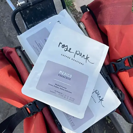 Bags of Rose Park Mexico Veracruz beans are strapped on the back of a delivery bike. 