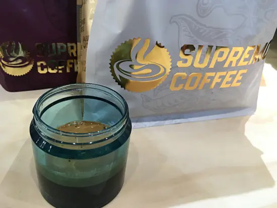 Two large bags of Supremo Coffee and a bit of coffee in small blue plastic jar.