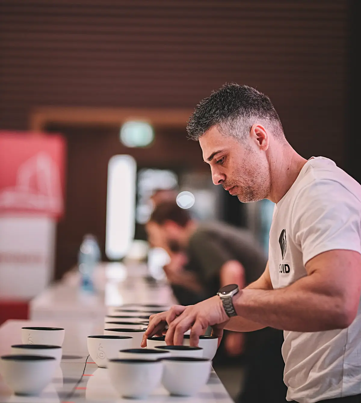 Cup tasters organizing cupping vessels on the competition table.