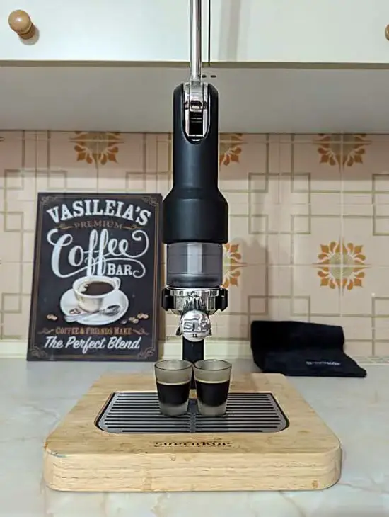 The Supkerop on the author's counter with two espresso shot glasses and a coffee sign in the background.